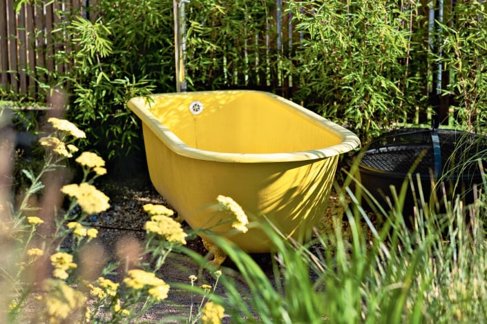 Žlutá vana se sprchou na zahradě